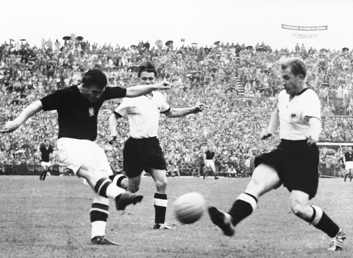 Hungary's Ferenc Puskas (l) lashes a shot at goal as West Germany's Werner Liebrich (r) tries to block