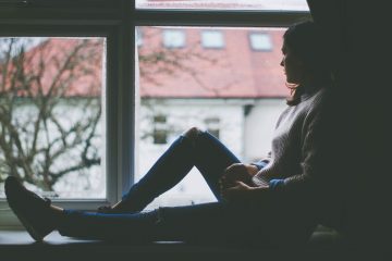 girl sitting next to window